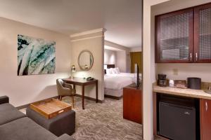 a hotel room with a bed and a living room at SpringHill Suites Lehi at Thanksgiving Point in Lehi