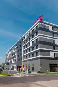 a large building with a pink bow on top of it at Moxy Milan Linate Airport in Segrate