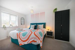 a bedroom with a large bed with a colorful bedspread at Spacious 3 bed house w/ garden, parking, WiFi, TV in Coventry