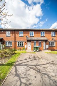 an empty street in front of a brick building at Spacious 3 bed house w/ garden, parking, WiFi, TV in Coventry