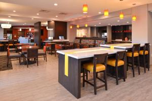 um restaurante com um bar com cadeiras e mesas em TownePlace Suites by Marriott Laplace em Laplace