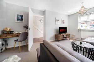 uma sala de estar com um sofá e uma mesa em Spacious 3 bed house w/ garden, parking, WiFi, TV em Coventry