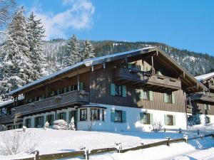 un grand bâtiment avec de la neige devant lui dans l'établissement Inviting Apartment in Bayrischzell with 2 Sauna, Garden and Terrace, à Bayrischzell