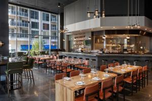 a restaurant with tables and chairs and a bar at Epicurean Atlanta, Autograph Collection in Atlanta