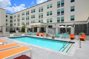 una piscina en un hotel con sillas y un edificio en Aloft Austin Round Rock, en Round Rock