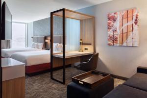 a hotel room with two beds and a desk with a mirror at SpringHill Suites by Marriott Orlando at Millenia in Orlando