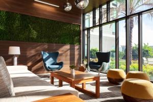 a living room with couches and chairs and a table at SpringHill Suites by Marriott Orlando at Millenia in Orlando