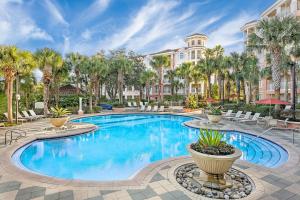 uma piscina com palmeiras e um edifício em Marriott's Grande Vista em Orlando