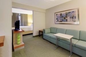 a living room with a couch and a tv at SpringHill Suites by Marriott Pittsburgh Washington in Washington