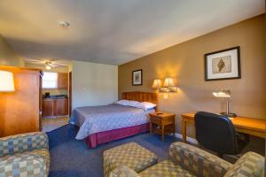 a hotel room with a bed and a desk and chairs at Alpine Motor Inn in Alma