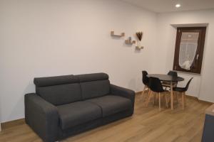 uma sala de estar com um sofá e uma mesa em Nel Cuore del Borgo "Superior" em Vitorchiano