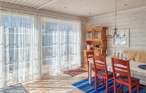 - une salle à manger avec une table, des chaises et des fenêtres dans l'établissement Amazing Home In Hllekis With Lake View, à Lugnås