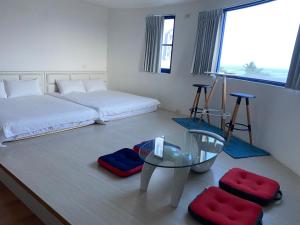 a bedroom with a bed and a glass table at Fuyue Sea View B&B in Taitung City