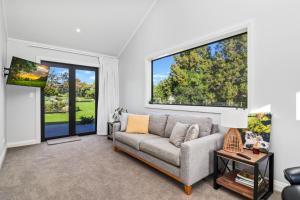 a living room with a couch and a window at Sanctuary Ridge in Tauranga
