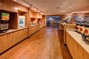 TownePlace Suites by Marriott Auburn University Area في أوبورن: مطعم بجدران خشبية وارضيات خشبية ومكتب