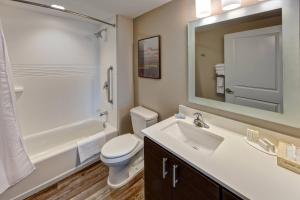 a bathroom with a sink and a toilet and a mirror at TownePlace Suites by Marriott Auburn University Area in Auburn