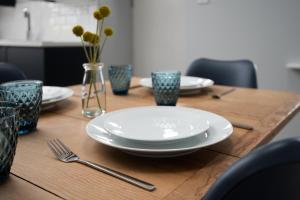 una mesa de madera con platos y utensilios. en Millers Cottage en Berwick-Upon-Tweed