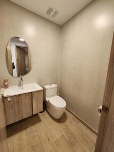 a bathroom with a toilet and a sink and a mirror at Suite departamento de lujo sector la Carolina in Quito +17 photos