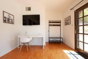 a room with a desk and a television on a wall at Malibu Peaceful Cottage, Near Beach & Hiking Trails in Malibu