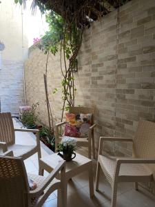 a patio with chairs and a table and a brick wall at شقة مفروشة خاصه بالخبر in Al Khobar
