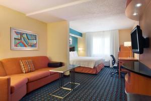 a hotel room with a couch and a bed at Fairfield Inn & Suites Waco South in Waco