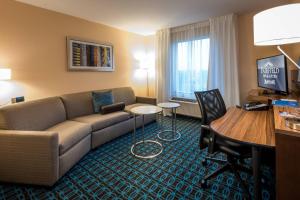 una sala de estar con sofá y escritorio en una habitación de hotel en Fairfield Inn & Suites by Marriott Enterprise, en Enterprise