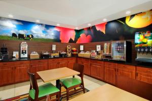 un ristorante con bancone, tavolo e sedie di Fairfield Inn & Suites Colorado Springs South a Colorado Springs