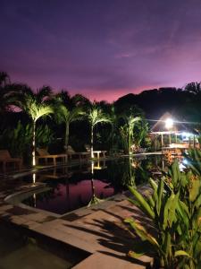 a night view of a pool at a resort at Palm Green Hotel in Kuta Lombok