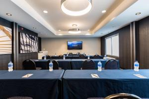 a conference room with blue tables and chairs and a screen at Fairfield Inn & Suites Raleigh Durham Airport Research Triangle Park in Morrisville