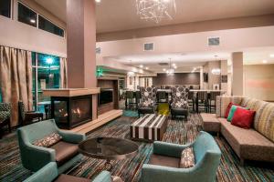 ラピッドシティにあるResidence Inn by Marriott Rapid Cityのソファ、暖炉、バーが備わるロビー