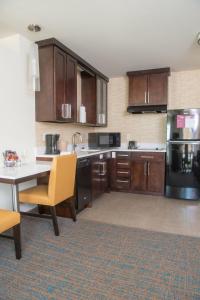 a kitchen with wooden cabinets and a table with a yellow chair at Residence Inn by Marriott Rapid City in Rapid City