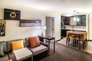 a living room with a couch and a table and a kitchen at Residence Inn by Marriott Rapid City in Rapid City