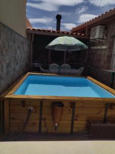 una piscina en un patio trasero con sombrilla en VUT Flor de Romero, en Los Yébenes