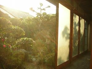 a window of a house with a view of a garden at Guesthouse Nara Backpackers in Nara