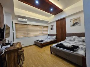 a living room with a bed and a desk at CedarPeak419 in Baguio