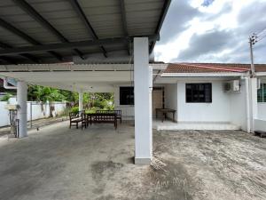 a covered patio with a table and a bench at Joyful homestay Miri in Miri