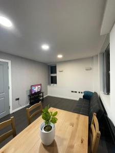 uma sala de estar com um sofá e uma mesa em Charming Modern Apartment near London Heathrow em Feltham