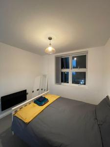 a bedroom with a bed and a window at Charming Modern Apartment near London Heathrow in Feltham