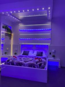 ナポリにあるB&B porta capuanaのベッドルーム1室(紫色の照明付きのベッド1台付)