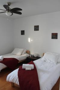 a room with two beds and a ceiling fan at La Roue Dort in Saint-Raymond