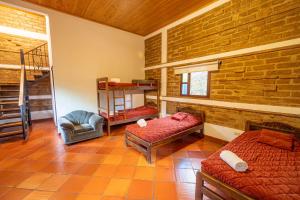 Hotel Casa Elemento Villa de Leyva في فيلا دي ليفا: غرفه سريرين وكرسي فيها