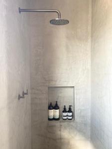 a shower with three bottles on a shelf in a bathroom at Chic Loft Style Apartment in Perth