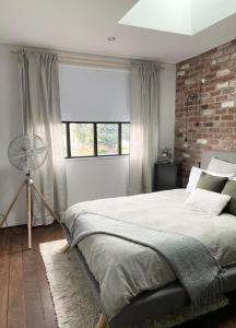a bedroom with a large bed and a brick wall at Chic Loft Style Apartment in Perth