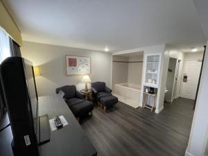 a living room with a bed and a tub in a room at Baymont by Wyndham Branford/New Haven in Branford