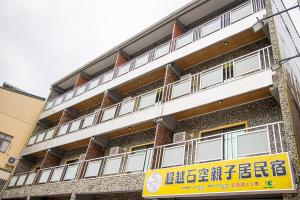 a building with a yellow sign in front of it at 宜家莊親子民宿 in Donggang