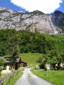 een weg die leidt naar een berg met een waterval bij Ferien Cottage Flüehblüemli in Stechelberg