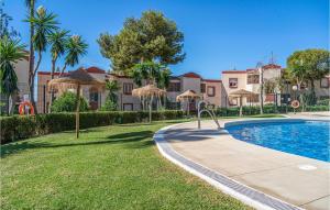 una piscina en un patio con palmeras en Stunning Apartment In Riviera Del Sol With Wifi, en Sitio de Calahonda