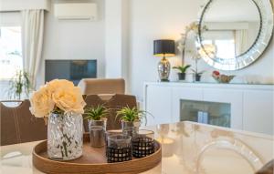 una mesa de comedor con un jarrón de flores y velas en Stunning Apartment In Riviera Del Sol With Wifi, en Sitio de Calahonda