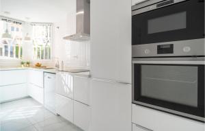 Sitio de CalahondaにあるStunning Apartment In Riviera Del Sol With Wifiのキッチン(白いキャビネット、黒いオーブン付)