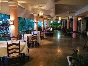 un comedor con mesas, sillas y luces en Hotel Catalina Beach Resort, en Zihuatanejo